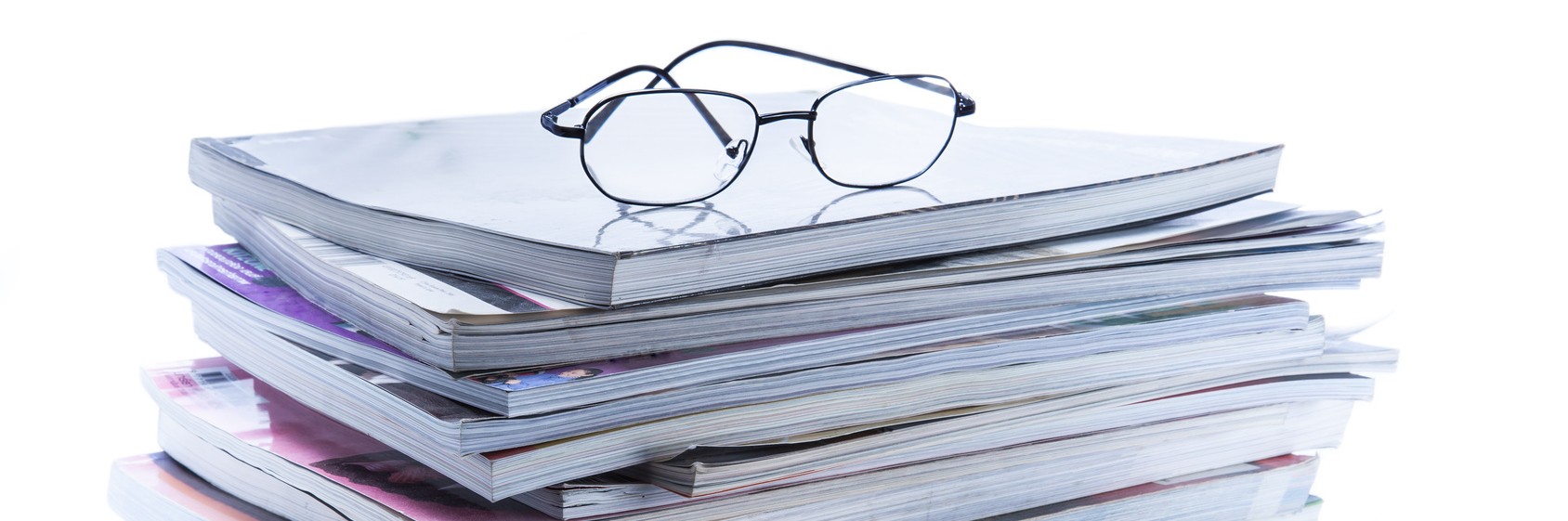 magazine and book stack with glasses